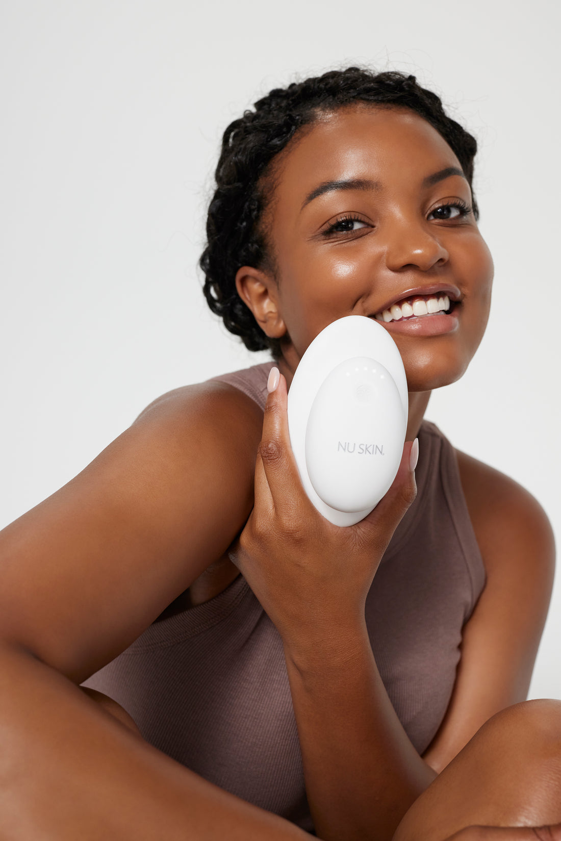 RenuSpa iO model holding the RenuSpa device